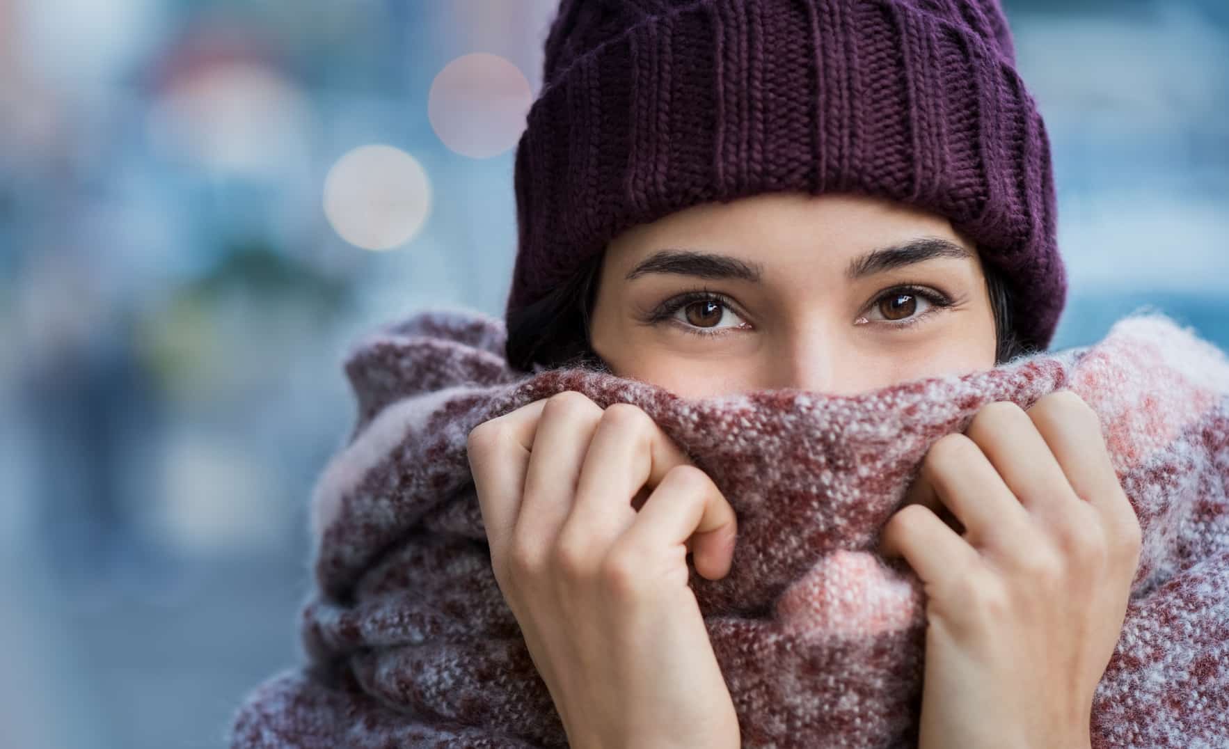 une personne ayant froid, se couvrant d'un bonnet, et d'une Ã©charpe