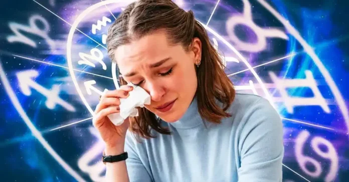 une femme en train de pleurer devant le cadran de signes astrologiques